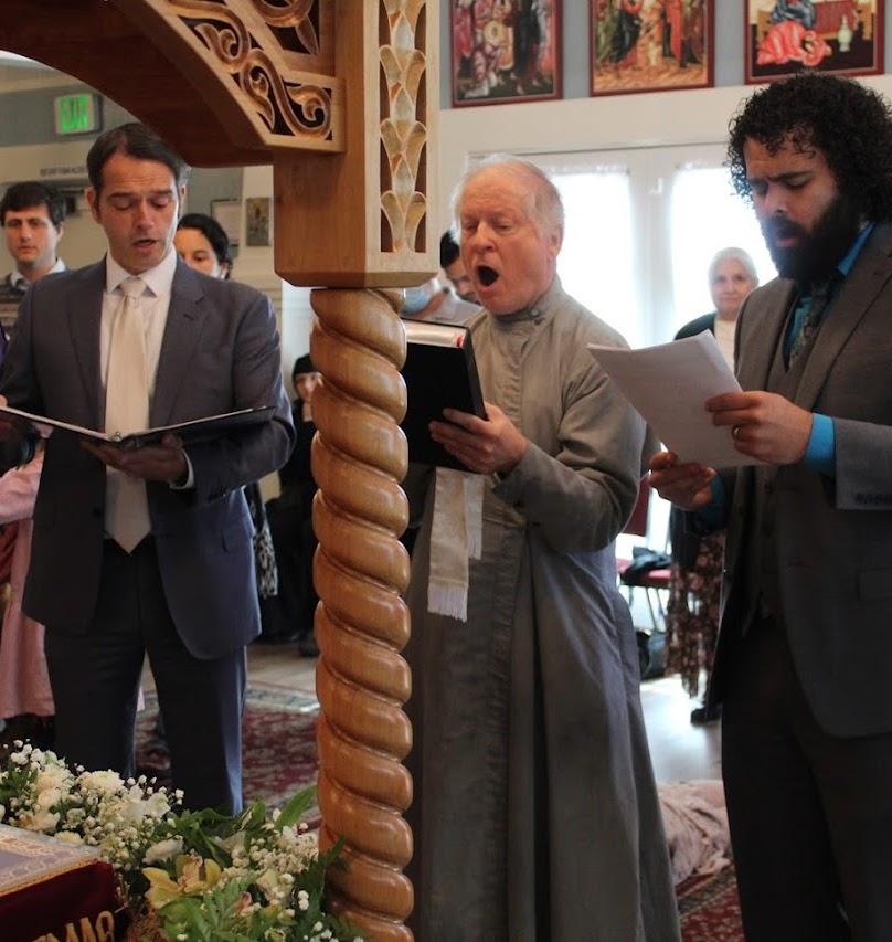 Orthodox male trio singing in front of bier during Holy Week.